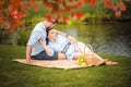 Happy joyful young family husband and his pregnant wife having fun together outdoors, at picnic in summer park Royalty Free Stock Photo