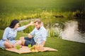 Happy joyful young family husband and his pregnant wife having fun together outdoors, at picnic in summer park Royalty Free Stock Photo