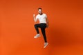 Happy joyful young man in casual white t-shirt posing isolated on bright orange wall background studio portrait. People Royalty Free Stock Photo