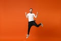 Happy joyful young man in casual white t-shirt posing isolated on bright orange wall background studio portrait. People Royalty Free Stock Photo