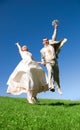 Happy jumping bride and groom on the hill