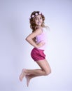 Happy jumping girl with bare feet and flowers in hair Royalty Free Stock Photo