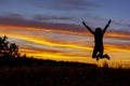 Happy jumping woman on the background of amazing sunset. Royalty Free Stock Photo