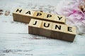 Happy June alphabet letters on wooden background