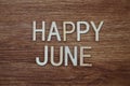 Happy June text message on wooden background