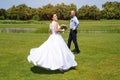 Happy just married young wedding couple having fun in the park. Bride and groom together, love and marriage theme. Royalty Free Stock Photo