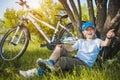 Happy kid with a bicycle resting under a tree Royalty Free Stock Photo