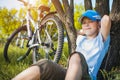 Happy kid with a bicycle resting under a tree Royalty Free Stock Photo