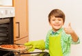 Happy kid boy cooking homemade pizza in the oven