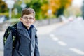 Happy kid boy with glasses and backpack or satchel. Schoolkid in stylish fashon coan on the way to middle or high school Royalty Free Stock Photo