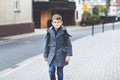 Happy kid boy with glasses and backpack or satchel. Schoolkid in stylish fashon coan on the way to middle or high school Royalty Free Stock Photo