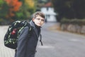 Happy kid boy with glasses and backpack or satchel. Schoolkid in stylish fashon coan on the way to middle or high school Royalty Free Stock Photo