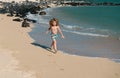 Happy kid boy have fun on tropical sea beach. Funny child run with splashes by water pool along surf edge. Kids activity Royalty Free Stock Photo