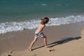 Happy kid boy have fun on tropical sea beach. Funny child run with splashes by water pool along surf edge. Kids activity Royalty Free Stock Photo