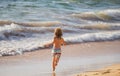 Happy kid boy have fun on tropical sea beach. Funny child run with splashes by water pool along surf edge. Kids activity Royalty Free Stock Photo