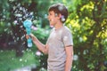 Happy kid boy having fun with blowing soap bubble blower. Preteen child playing on sunny summer day. Happy active funny Royalty Free Stock Photo