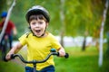 Happy kid boy of 6 years having fun in autumn forest with a bicycle on beautiful fall day. Active child making sports. Safety, sp Royalty Free Stock Photo