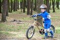 Happy kid boy of 4 years having fun in autumn forest with a bicycle on beautiful fall day. Active child making sports. Safety, lei Royalty Free Stock Photo