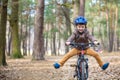 Happy kid boy of 3 or 5 years having fun in autumn forest with a bicycle on beautiful fall day. Active child wearing bike helmet.