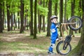 Happy kid boy of 4 years having fun in autumn or summer forest with a bicycle Royalty Free Stock Photo