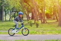 Happy kid boy of 5 years having fun in spring park with a bicycle on beautiful fall day. Active child wearing bike helmet Royalty Free Stock Photo