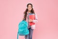 Happy kid carry school bag and language learning books wearing headphones pink background, English Royalty Free Stock Photo