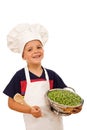 Happy kid with chef hat and a bowl of green peas Royalty Free Stock Photo