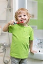 Happy kid or child brushing his teeth in bathroom. Dental hygiene. Royalty Free Stock Photo