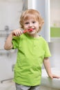 Happy kid or child brushing teeth in bathroom. Dental hygiene. Royalty Free Stock Photo