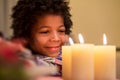 Happy kid beside Christmas candle.