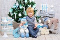 Happy kid by the Christmas tree Royalty Free Stock Photo
