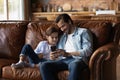 Happy kid and dad resting on on couch at home Royalty Free Stock Photo