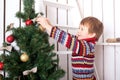 Happy kid decorating the Christmas tree with balls. Royalty Free Stock Photo