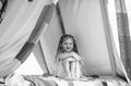 Happy kid with dreadlocks play in tent. Child camping concept. Girl playing in camp. Having fun outdoors at campground.