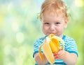 Happy kid eating banana fruit. healthy food eating concept.