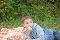 Happy kid eating fruits. happy cute child boy eating an apple. lies on a coverlet in an autumn park Royalty Free Stock Photo