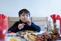 Happy kid eating sunday dinner at home, Child boy having Chirstmas lunch with family