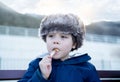 Happy kid enjoying eating potato chips for sunday lunch, Cute boy eating french fries. Child siting on bench having picnic outdoor