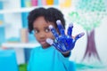 Happy kid enjoying painting with his hands