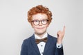 Happy kid with ginger hair pointing up and smiling on white background Royalty Free Stock Photo