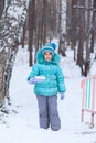 Happy kid girl child outdoors in winter digging snow