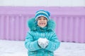 Happy kid girl child outdoors in winter playing holding snow Royalty Free Stock Photo