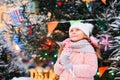 Happy kid girl with christmas candy. Winter holiday portrait at christmas tree Royalty Free Stock Photo