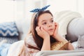Happy kid girl close up portrait. Preteen relaxing at home on cozy couch