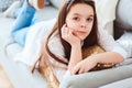 Happy kid girl close up portrait. Preteen relaxing at home on cozy couch