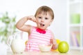 Happy kid girl eating food itself with spoon Royalty Free Stock Photo