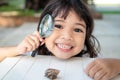 Happy kid girl exploring nature with a magnifying glass and a snail. He having fun in the garden. The concept of the kid is ready Royalty Free Stock Photo