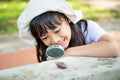 Happy kid girl exploring nature with a magnifying glass and a snail. He having fun in the garden. The concept of the kid is ready Royalty Free Stock Photo