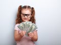 Happy kid girl in glasses holding money in the hand and looking Royalty Free Stock Photo