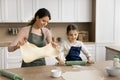 Happy kid girl helping mom to bake, preparing homemade pies Royalty Free Stock Photo